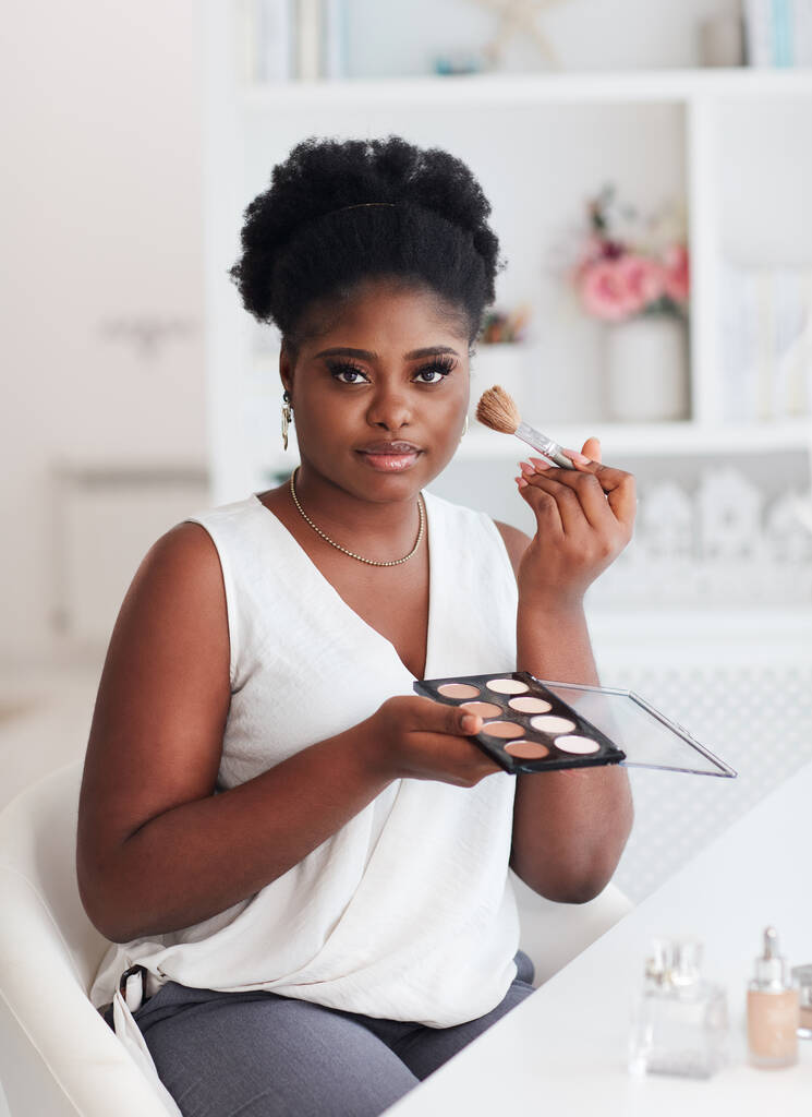 Güzel Afro-Amerikan Kadın makyajını evde profesyonel kozmetik ürünleriyle yapıyor. - Fotoğraf, Görsel
