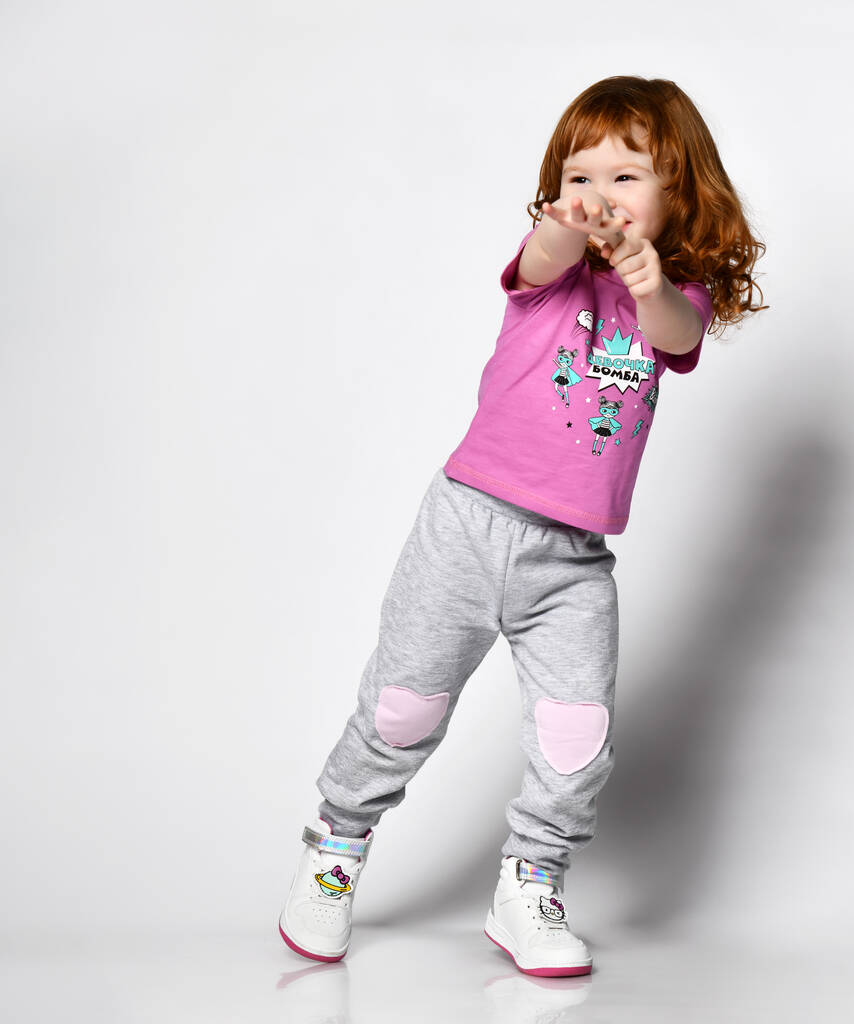 Full length portret van een vrolijk schattig meisje springen op een witte achtergrond - Foto, afbeelding
