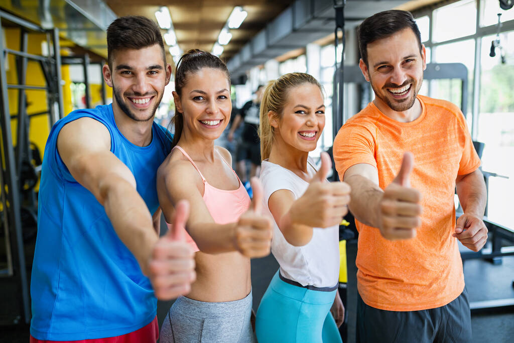 Groupe de jeunes gens en forme faisant des exercices dans la salle de gym pour rester en bonne santé. Sport, ami, concept d'entraînement - Photo, image