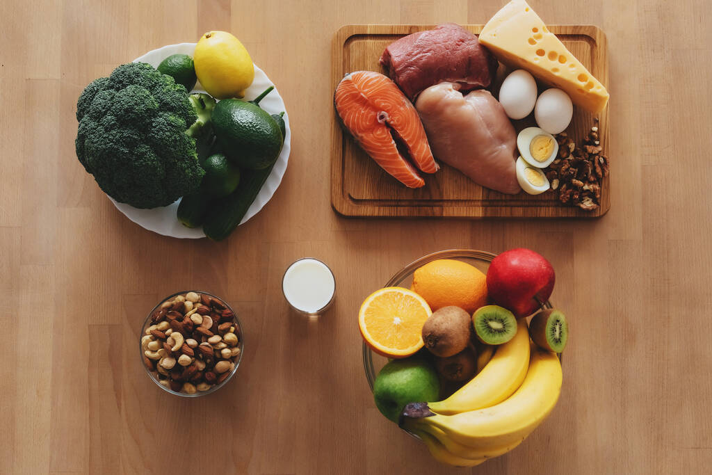 Photo de table de produits carnés, légumes, fruits et noix disposés sur la surface en bois - Photo, image