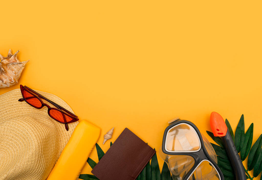 Reisaccessoires hoed, zwembril, schelpen, zonnebrandcrème, bovenaanzicht op gele achtergrond met kopieerruimte. Strand avontuur en liefde voor reizen concept met strand accessoires. Zonnebaden en ontspannen - Foto, afbeelding