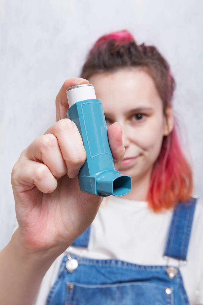 Woman holds inhaler to treat asthma. World Asthma Day. Concept of allergy care - Photo, Image