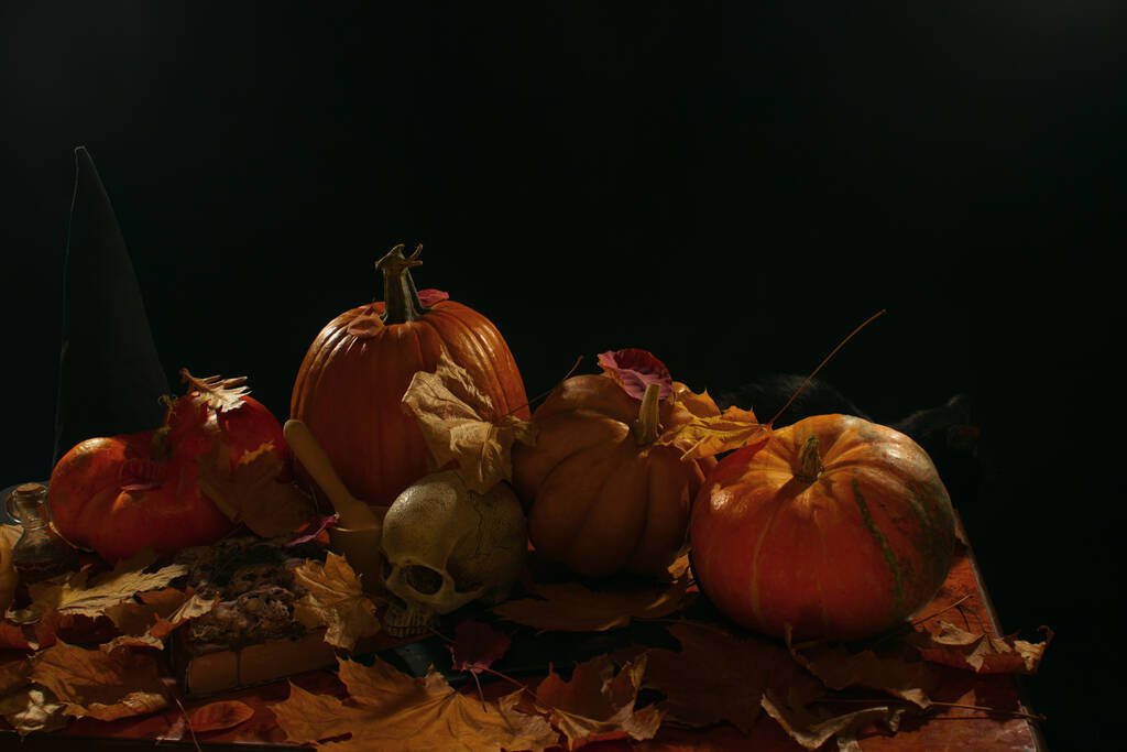 Calavera, calabazas y hojas de otoño sobre una mesa  - Foto, Imagen