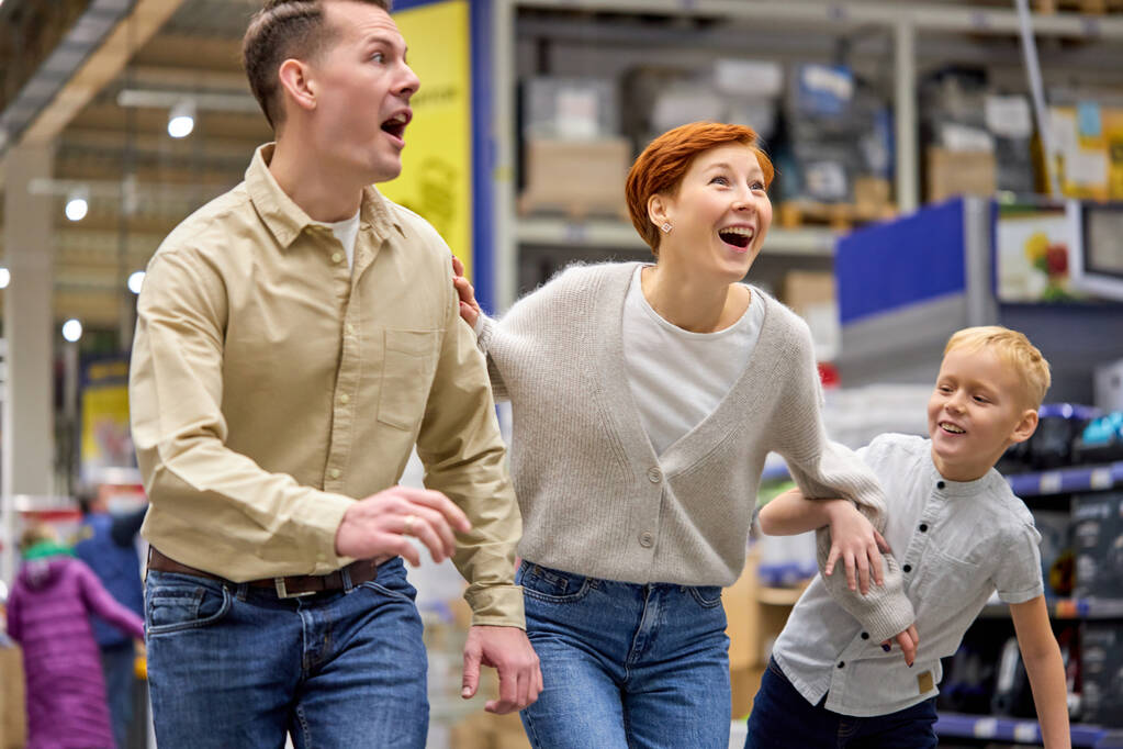 Wesoła rodzina dobrze się bawi podczas wyboru rzeczy w supermarkecie - Zdjęcie, obraz