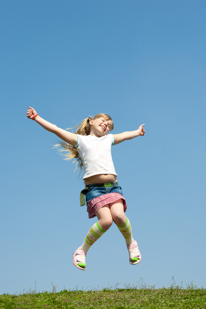 Pieni tyttö hyppää kaunista taivasta vasten
 - Valokuva, kuva