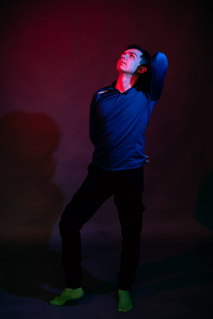 黒を背景に青と赤の光を持つスタジオの男の感情 - 写真・画像