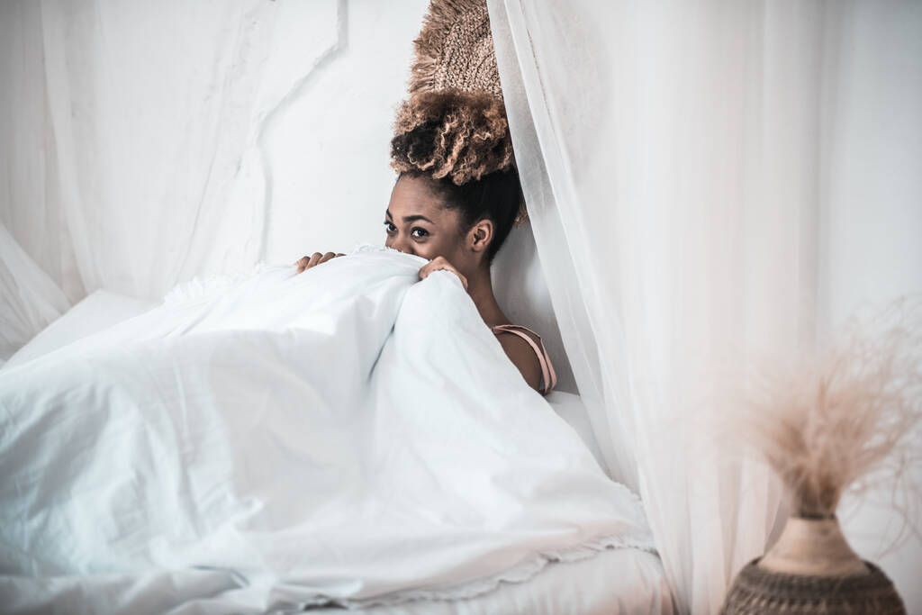 Африканская американка под белым одеялом в постели - Фото, изображение