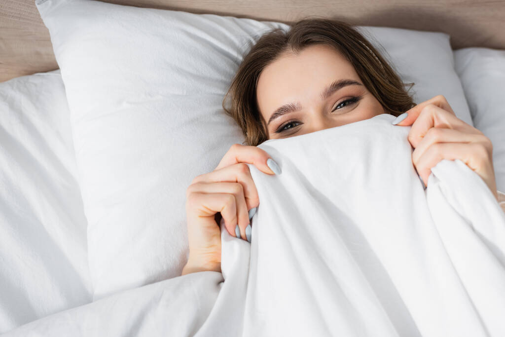 Top view of young woman covering face with blanket  - Photo, Image