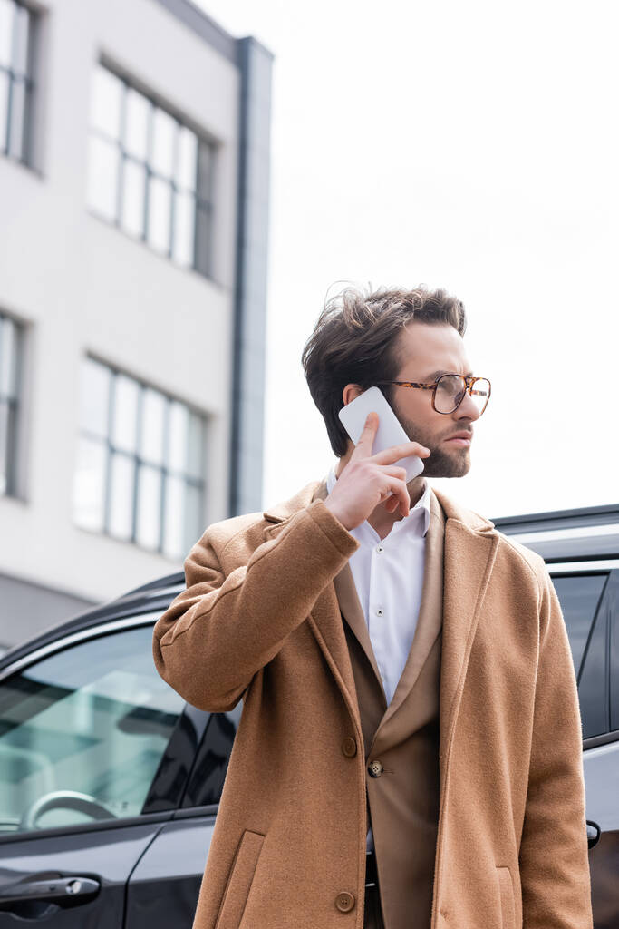 liikemies lasit ja takki puhuu puhelimessa auton lähellä  - Valokuva, kuva