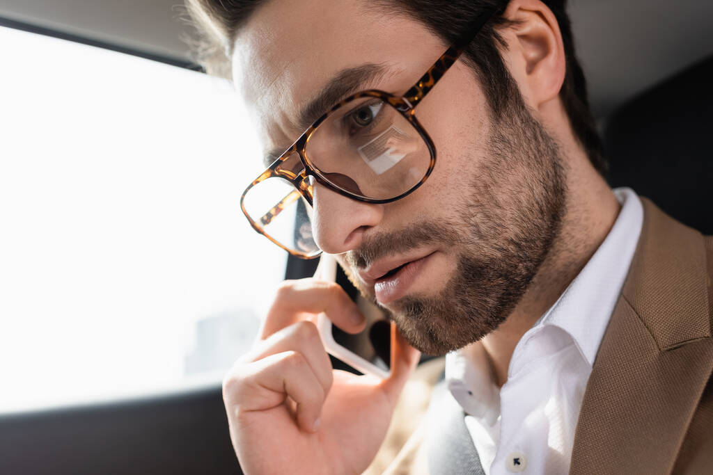 primer plano del hombre barbudo hablando en smartphone en coche - Foto, imagen
