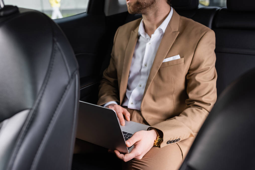 partial view of businessman in suit working remotely in car - Zdjęcie, obraz