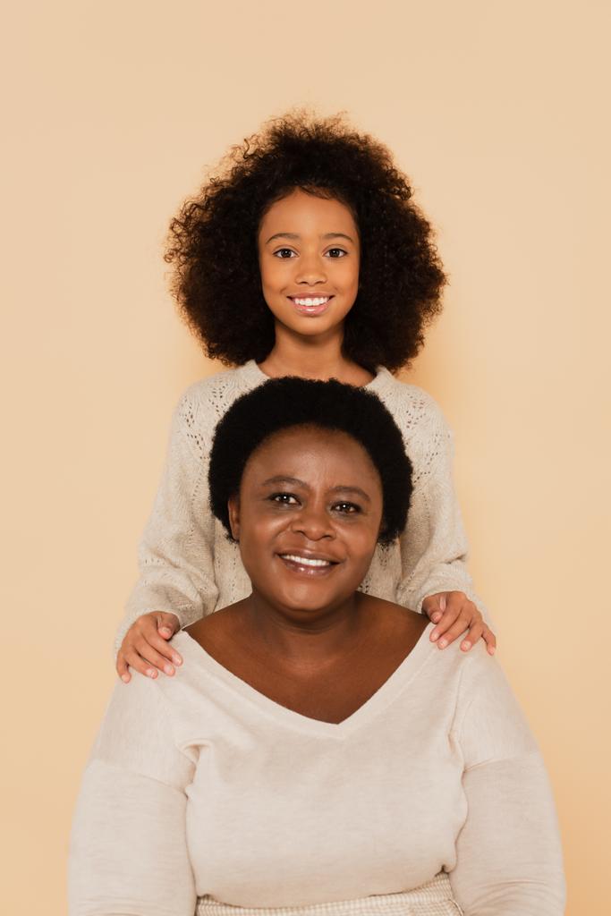 joyeuse petite-fille afro-américaine avec grand-mère isolée sur beige - Photo, image