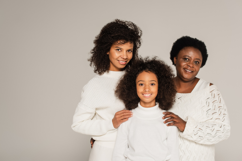 Χαρούμενη αφροαμερικανική οικογένεια της γιαγιάς, της κόρης και της εγγονής στέκεται μαζί απομονωμένα σε γκρι - Φωτογραφία, εικόνα