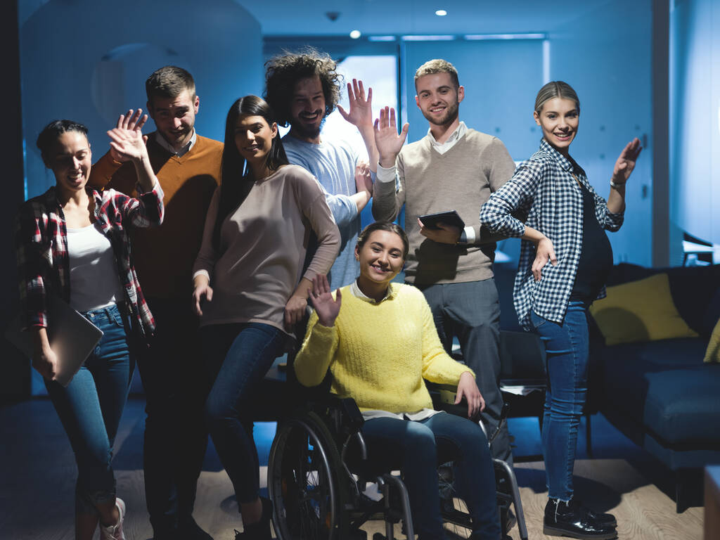 Niepełnosprawna bizneswoman na wózku inwalidzkim w biurze z zespołem współpracowników - Zdjęcie, obraz