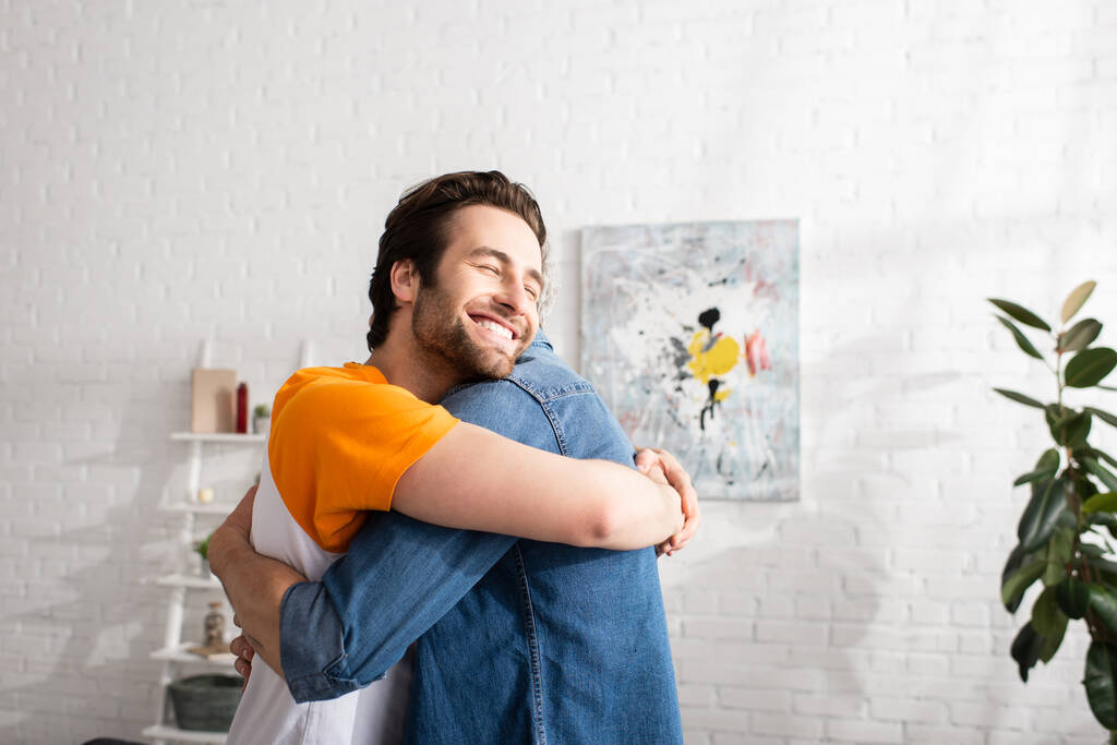 Young son smiling and hugging father at home  - Photo, Image