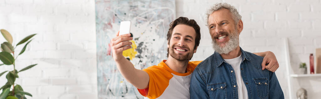 Sorrindo filho tomando selfie com o pai em casa, banner  - Foto, Imagem