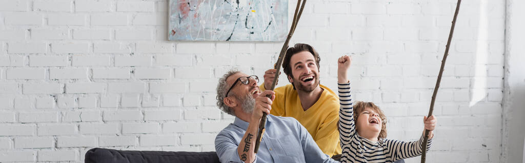 興奮した男性と男の子自宅で木製の小枝を保持し、バナー  - 写真・画像