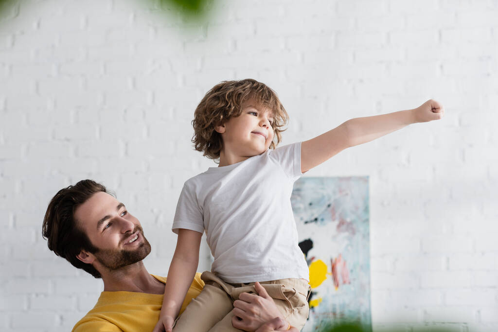 Man holding smiling son gesturing at home  - Photo, Image