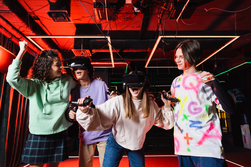 african american teenage girl showing triumph gesture near amazed friends in vr headsets - Photo, Image