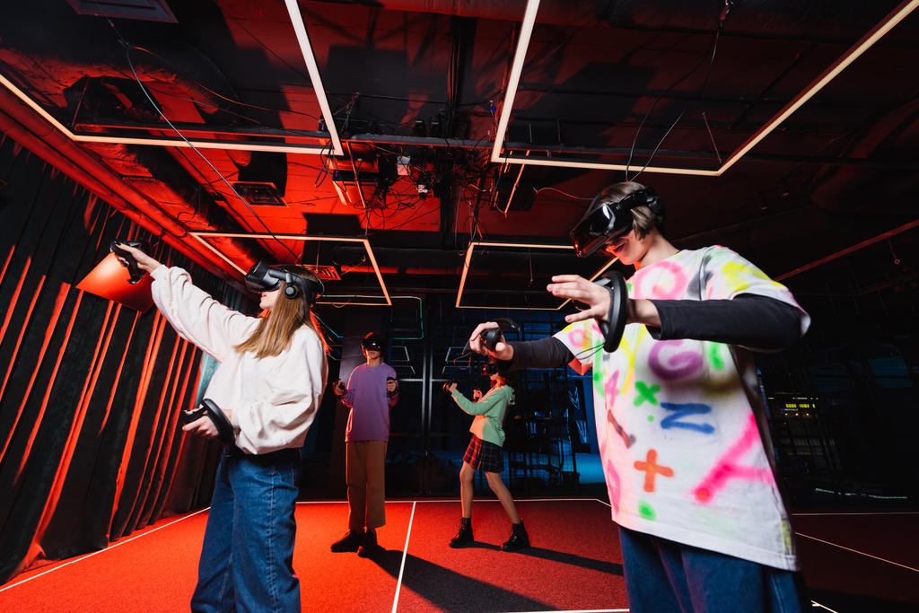 межрасовые подростки играют в виртуальные наушники в игровой зоне - Фото, изображение