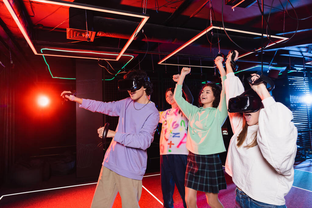izgatott multikulturális barátok mutatja diadal gesztus közelében tizenévesek IV vr headset - Fotó, kép