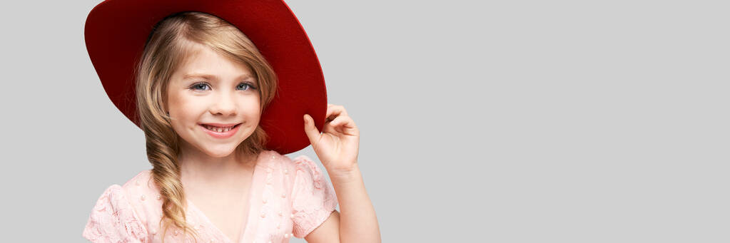 Kis aranyos lány rózsaszín ruhában és vörös hajjal. Stúdió portré - Fotó, kép