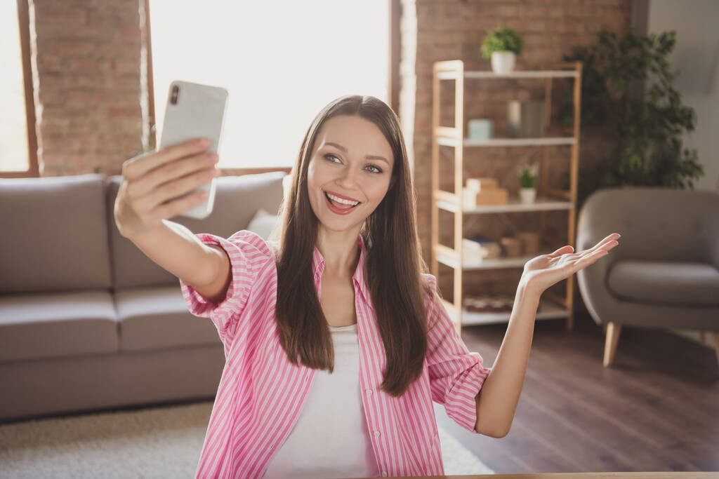 Foto di attraente positivo giovane donna tenere la mano spettacolo gesto fare selfie dentro casa appartamento al chiuso - Foto, immagini