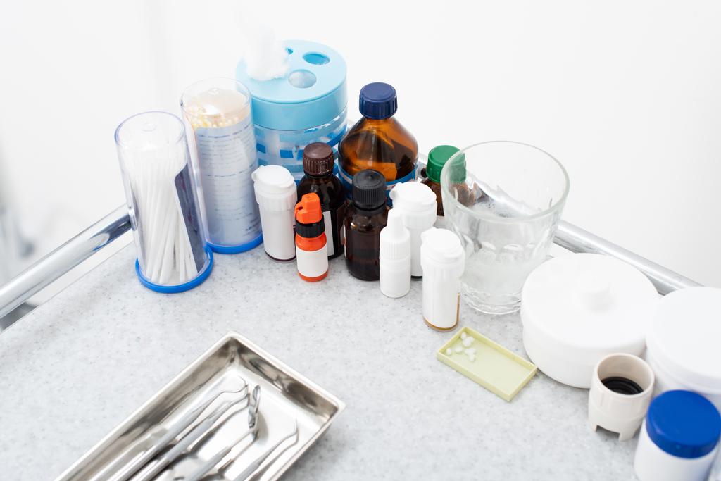 vista ad alto angolo dei medicinali e strumenti dentali inossidabili puliti in vassoio sul tavolo medico - Foto, immagini