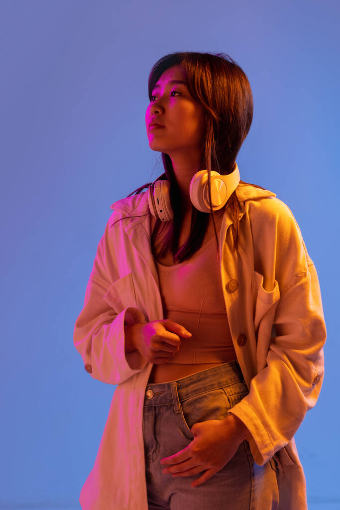 Azjatycki młody kobieta portret na gradientowy studio tło w neon. Pojęcie ludzkich emocji, ekspresji twarzy, młodzieży, sprzedaży, reklamy. - Zdjęcie, obraz