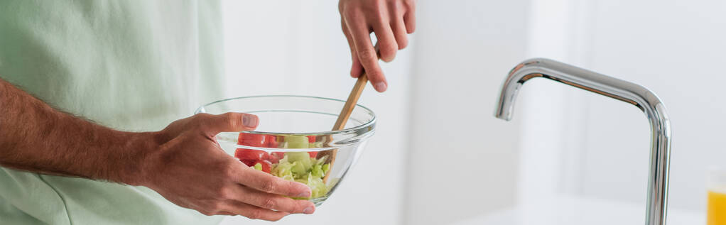 vista recortada del hombre mezclando ensalada de verduras frescas en un tazón, pancarta - Foto, imagen