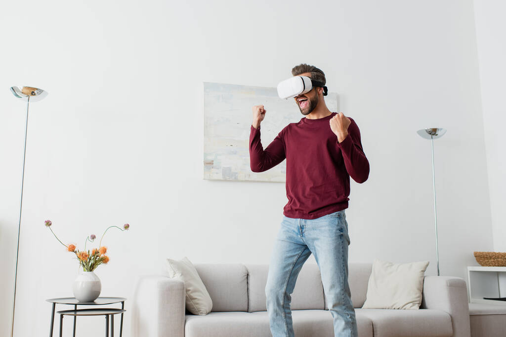 excited man in vr headset shouting while showing triumph gesture - Photo, Image