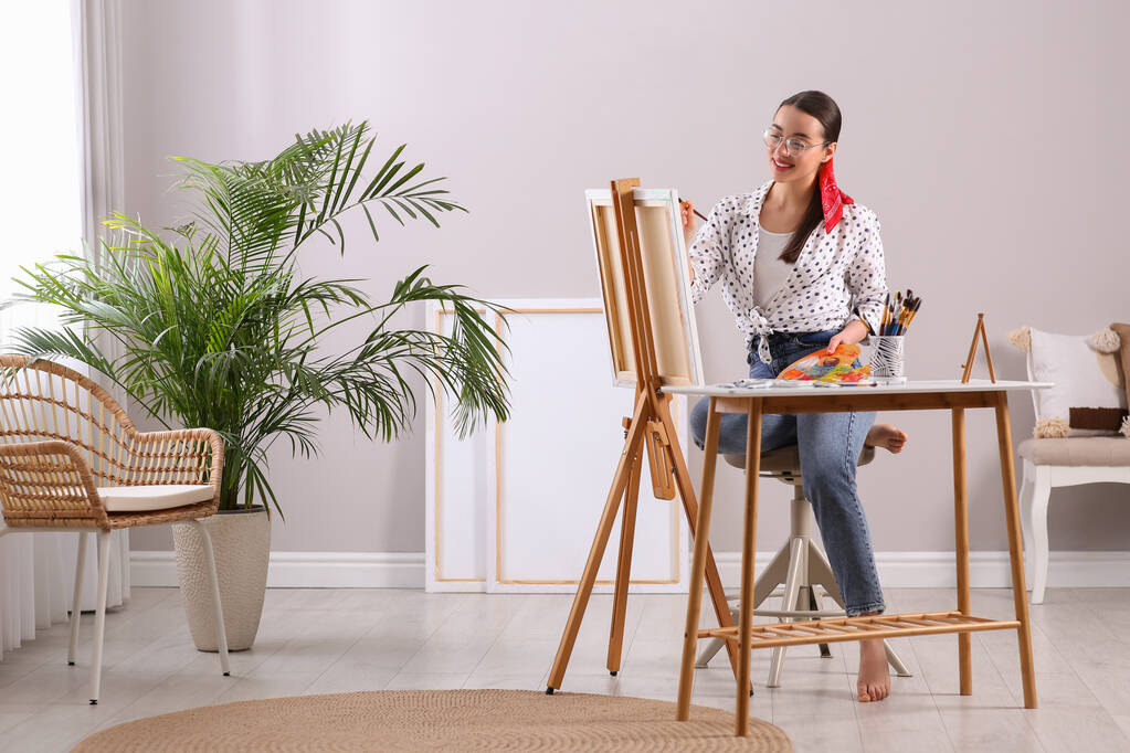 Щаслива жінка художник малює картину на полотні в студії
 - Фото, зображення
