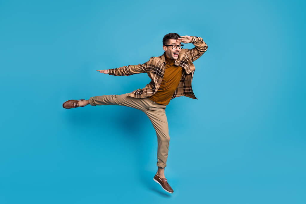 Pełnowymiarowe zdjęcie młodego beztroskiego funky podekscytowany uśmiechnięty człowiek skok wygląd copyspace izolowane na tle niebieskiego koloru - Zdjęcie, obraz