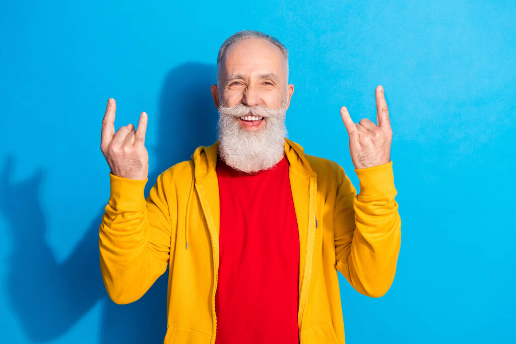 Foto portrét starého muže ukazuje těžké kovové gesto izolované na pulzujícím modrém pozadí - Fotografie, Obrázek