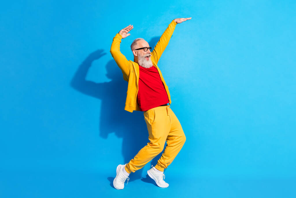 Teljes méretű profil oldalán fotó funky vicces őrült mosolygós nagyapa néz copyspace tánc elszigetelt kék színű háttér - Fotó, kép