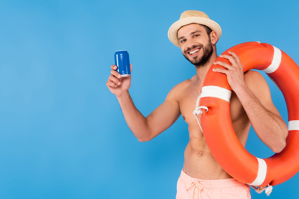 Muž bez trička, držící životní bóji a konzervovaný nápoj izolovaný na modré  - Fotografie, Obrázek