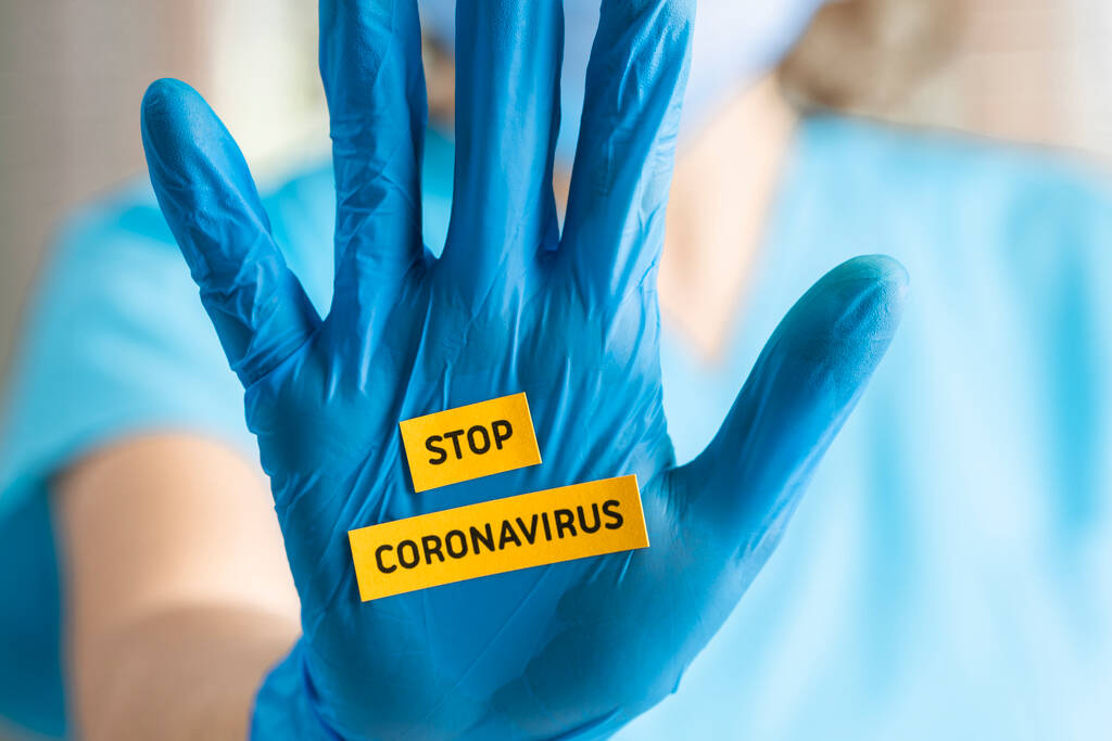 Mladý lékař rukou gestikulace STOP Coronavirus COVID-19 nemoc globální ohnisko, prosím, pomoci šířit virus po celém světě, zůstat doma a sociální fyzické vzdálenosti - Fotografie, Obrázek