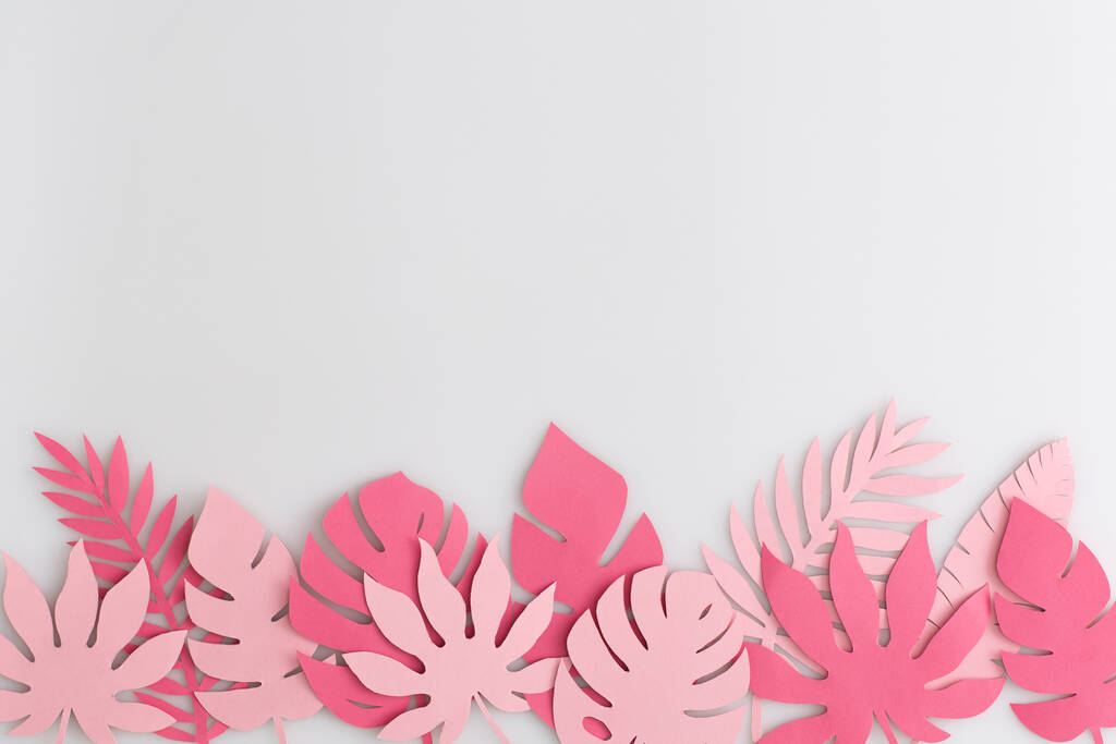 Tropické růžové papírové listy na bílém pozadí.Letní koncept. Pohled shora, byt ležel. - Fotografie, Obrázek