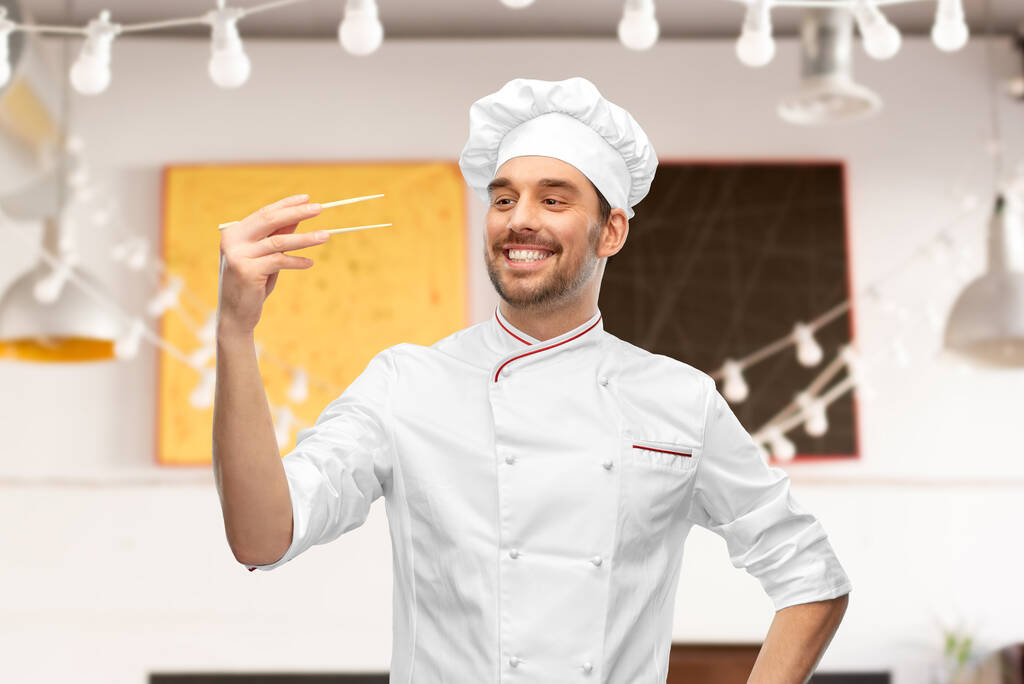 Счастливый улыбающийся шеф-повар с палочками для еды - Фото, изображение