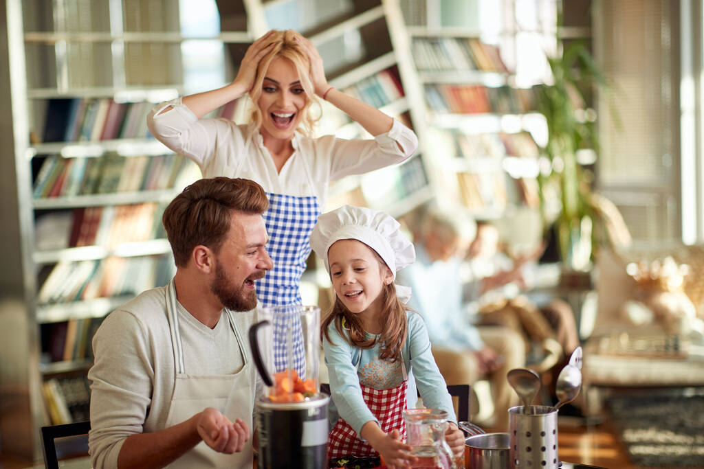 Eine junge glückliche Familie liebt es, zu Hause gemeinsam ein Essen in fröhlicher Atmosphäre zuzubereiten. Familie, Freizeit, gemeinsam - Foto, Bild