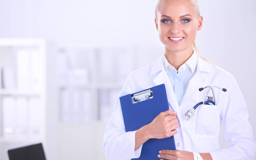 Женщина-врач стоит с папкой в больнице - Фото, изображение