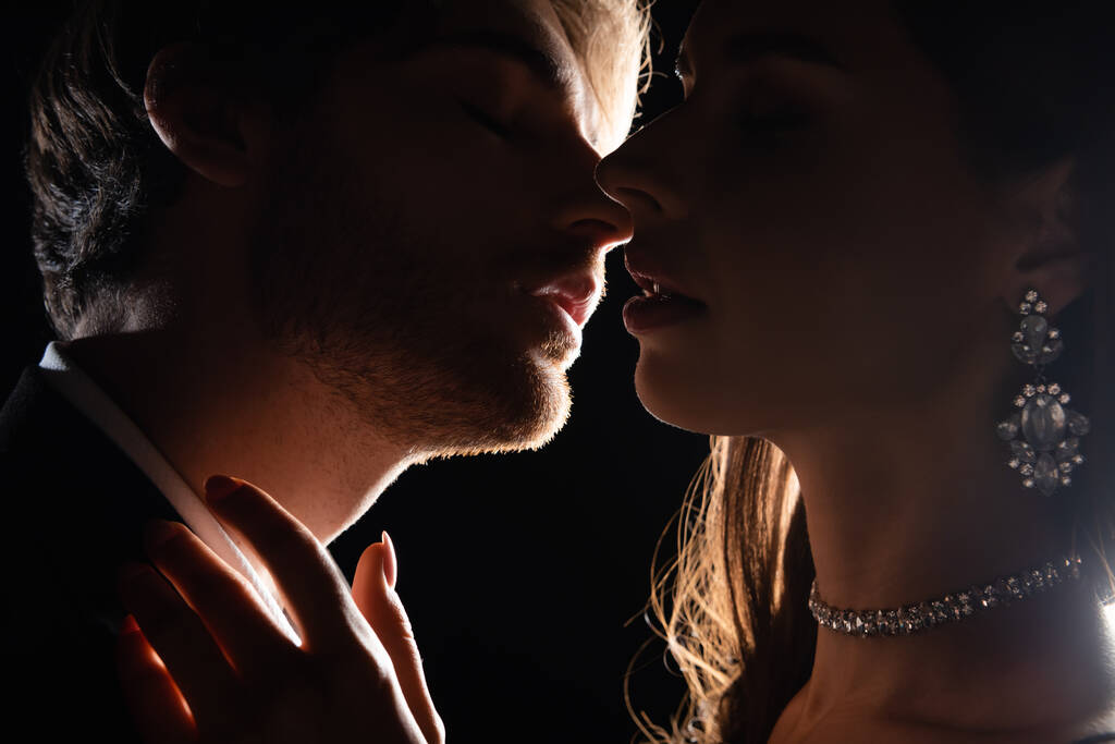 lähikuva houkutteleva tyylikäs pari varovasti suudella takana valossa eristetty musta - Valokuva, kuva