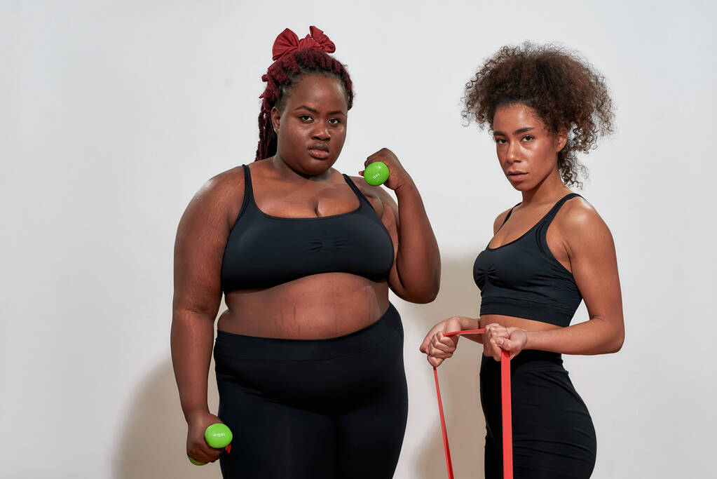 Bild von zwei Afro-Frauen mit Hanteln und Springseil, jeder kann Sport treiben  - Foto, Bild