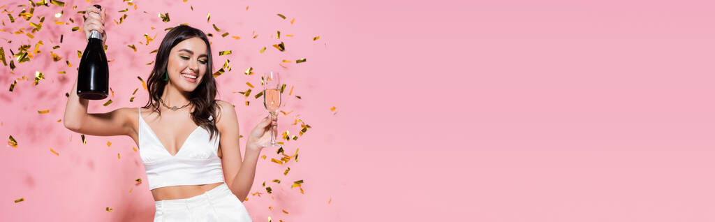 Stylowa kobieta z szampanem przy uroczystym konfetti na różowym tle, baner  - Zdjęcie, obraz