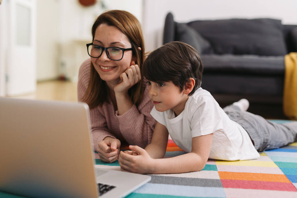 moeder en haar kind genieten van tijd samen thuis, met behulp van laptop computer - Foto, afbeelding