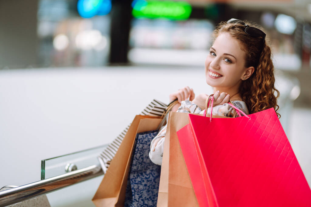 Модна жінка з різнокольоровими сумками в сучасному магазині. Радість від споживання. Споживацтво, продаж, покупки, покупки, концепція способу життя
. - Фото, зображення