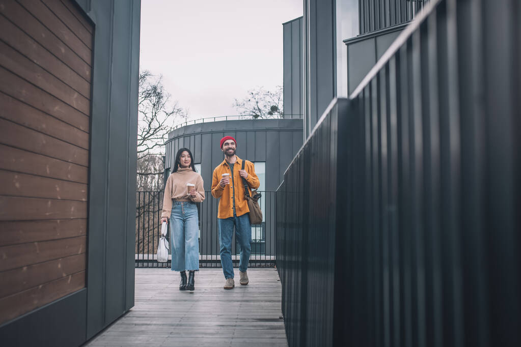 Giovane uomo e donna in abiti casual che camminano insieme - Foto, immagini