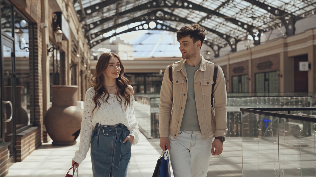 alegre hombre y mujer caminando con bolsas de compras en el centro comercial  - Foto, imagen
