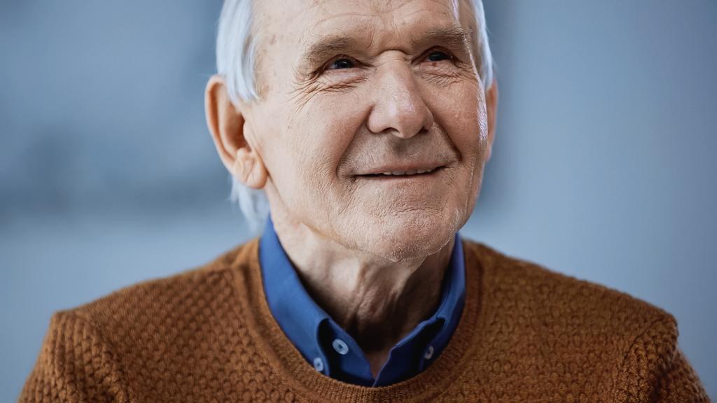 Gri arka plana bakan pozitif yaşlı bir adamın portresi  - Fotoğraf, Görsel
