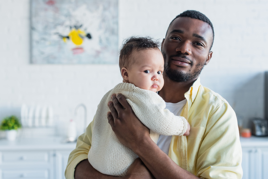 homme afro-américain embrassant bébé fille à la maison - Photo, image